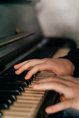 Eller zarif bir şekilde piyano çalar, müziğin, yaratıcılığın ve sanatsal ifadenin özünü yakın çekimde yakalar. Yüksek kalite fotoğraf