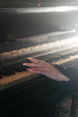 Antika piyano çalan bir kadının estetik yakın çekimi nostalji ve zarafeti çağrıştırıyor. Yüksek kalite fotoğraf