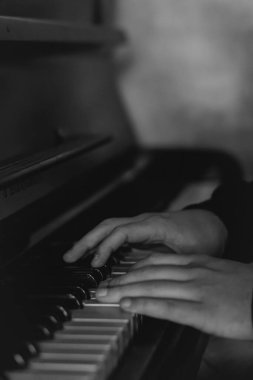 Eller zarif bir şekilde piyano çalar, müziğin, yaratıcılığın ve sanatsal ifadenin özünü yakın çekimde yakalar. Yüksek kalite fotoğraf