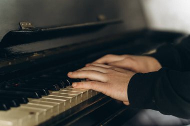 Eller zarif bir şekilde piyano çalar, müziğin, yaratıcılığın ve sanatsal ifadenin özünü yakın çekimde yakalar. Yüksek kalite fotoğraf