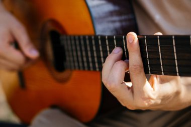 Genç adamlar dışarıda akustik gitar çalıyorlar. Yüksek kalite fotoğraf
