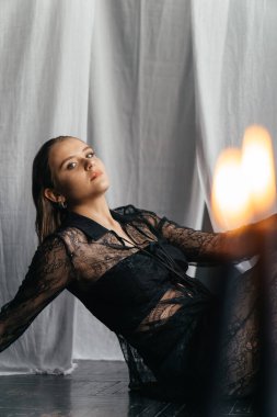 Siyah dantelli gizemli kadın mum ışığında yoğun bir şekilde bakıyor zarafet ve gotik cazibeyi çağrıştırıyor. Yüksek kalite fotoğraf