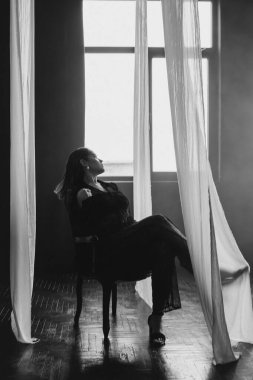 Saf siyah dantelli, kendine güvenen kadın beyaz perdeler arasında duruyor, somut güç, zarafet ve modern gotik moda. Yüksek kalite fotoğraf