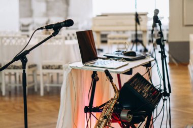 Diz üstü bilgisayar, saksafon ve mikrofonlarla sofistike bir düğün yeri DJ 'inde canlı performans için hazırlanmış zarif bir müzik seti. Yüksek kalite fotoğraf