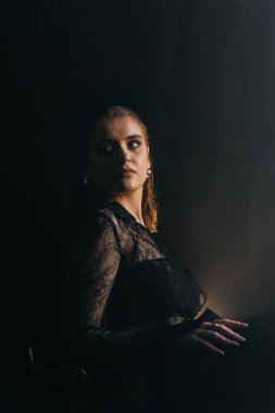 Gizemli bir kadın gölgeler ve dumanlarla çevrili parlak bir pencereye karşı siluet içinde duruyor. Yüksek kalite fotoğraf