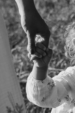 Sıcak, doğal ışıkta el ele tutuşan iki insanın yakınlaşması sevgi ve bağlantıyı simgeliyor. Yüksek kalite fotoğraf