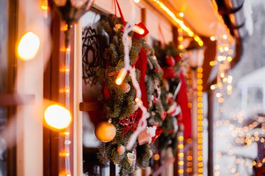 Süslü Noel çelengi, çam kozalakları, penceresinde çelenk ışıkları olan dallar. Şenlik dekorasyonu, kış tatili konsepti.