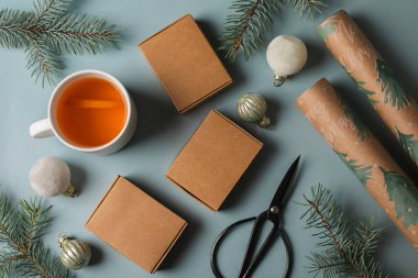 Noel arkaplanı hediye kutuları, köknar ağacı dalları, ambalaj kağıdı ve mavi kıyı şeridinde süslemeler. Düz yatıyordu