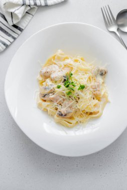 İtalyan makarnası fettuccine alfredo, tavuk, mantar ve tabakta sosis. - Yakın çekim. Üst görünüm