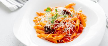 Domates soslu makarna ve açık beton arka planda beyaz bir tabakta kurutulmuş domates. Tasarım veya web sitesi için uzun pankart