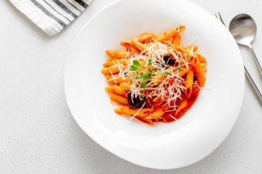 Domates soslu makarna ve beyaz tabakta kurutulmuş domates..