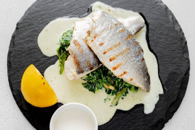 Izgarada ıspanak ve krema sosuyla pişirilmiş lezzetli dorado. Sağlıklı yiyecekler. Akdeniz diyeti.