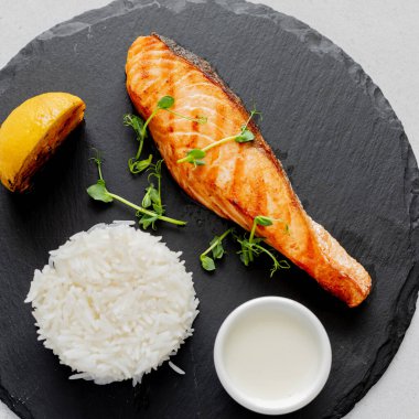 Somon bifteği ve tahta tabakta beyaz pirinç. Üst görünüm