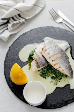 Izgarada ıspanak ve krema sosuyla pişirilmiş lezzetli dorado. Sağlıklı yiyecekler. Akdeniz diyeti.