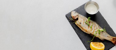 Limon ve mikro yeşille servis edilmiş ızgara deniz kabuğu. Kopyalama alanı olan üst görünüm. Tasarım için uzun pankart