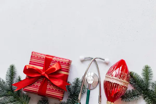 度假背景 有文字的地方 祝您圣诞快乐 医疗听诊器 礼品盒和圣诞装饰品 背景明亮 平躺在床上 图库照片