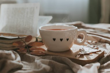 Bir fincan çay, yaprak ve kitapla sonbahar kompozisyonu