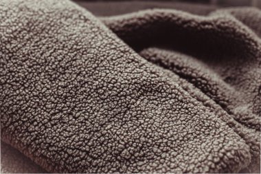 Kahverengi bulanık tekstil yüzeyi yoğun örgü dokusunun detaylı bir yakın çekimi, arka plan ya da tasarım amaçları için mükemmel. Yıl 2025 Mocha Mousse rengi.