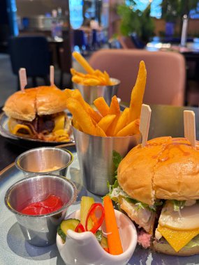 Taze hamburger ve patates kızartması. Tabakta ketçap var.