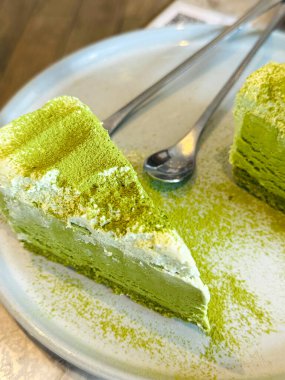 Tabağında gümüş çatal olan yeşil kibritli pasta.