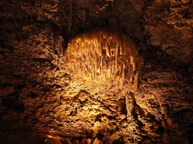 Mağarada sarı ışığı olan dev bir Stalactites taşı.