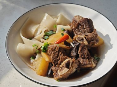 Taze sığır güveci, patates ve kasedeki geniş erişteler yemek için.