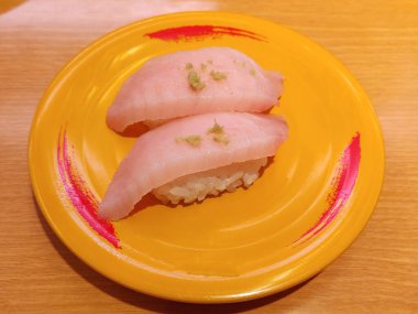 fresh pink fish meat sushi on the yellow plate for eating clipart