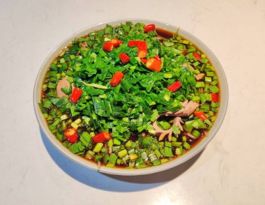 Taze pişmiş domuz böbreği. Tabağında yeşil Çin pırasası ve kırmızı biber var.