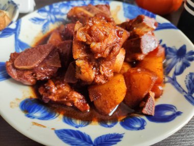 Mavi tabakta patatesli haşlanmış domuz eti.