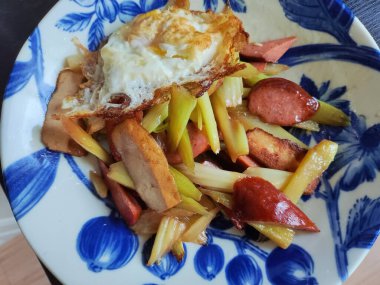 Kereviz, jambonlu ve yumurtalı, yemek için mavi tabakta.