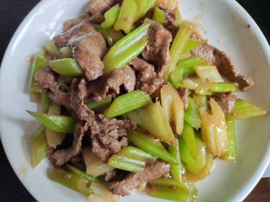 Beyaz tabakta taze et ve kereviz.