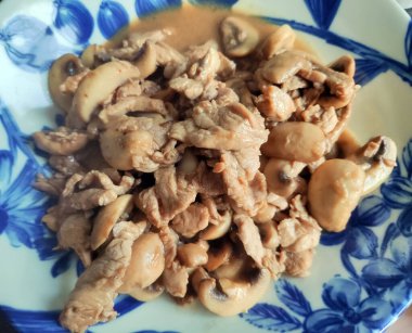 Mavi tabakta mantarlı taze domuz eti.