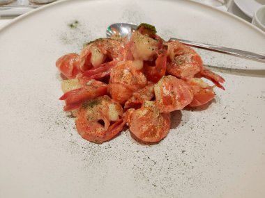 Beyaz tabakta soslu taze kızarmış karides yemek için.