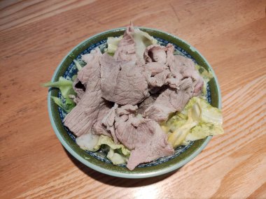 Tabaktaki lahanada taze et dilimi yemek için.