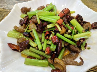 Kereviz sapı yemek için beyaz tabakta domuz bağırsağıyla çırpılmış.