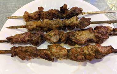 Beyaz tabakta dört taze kebap hazır.