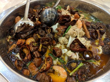 Baharatlı çorbada biberli haşlanmış deniz ürünleri.