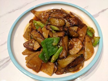 Patlıcanlar yeşil biber ve patates tabağında yenir.