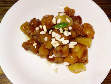 Beyaz tabakta çam fıstıklı tatlı ve ekşi domuz eti