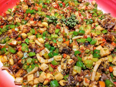 Farklı et ve sebzeler parlak ışık altında tabakta çırpılmış.