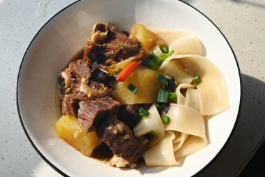 Eriştenin üzerinde patates ve haşlanmış et yemek için.