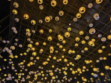 Çatıda farklı sarı ampul grupları asılı.