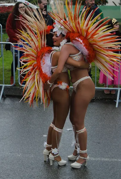 İki maskeli balerin bir sokak karnavalında birbirlerine sarılıyorlar. Bu da bir dostluk ve sevgi göstergesi.