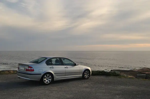 Portekiz kıyısında deniz kenarında gökyüzünde bulutlar olan Alman markalı bir araba durduruldu.