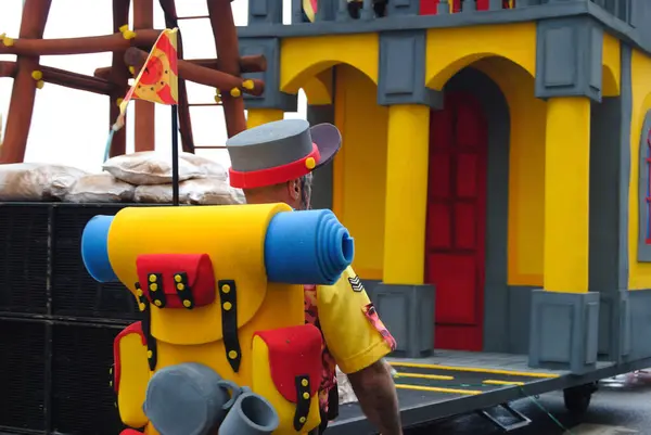 Bir sokak partisinde erkek izci gibi giyinmiş bir adam.