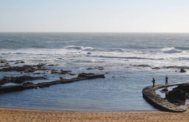 Balığa gidelim, deniz kıyısında iki balıkçı ile birlikte yuvarlak bir duvar örelim, küçük bir sahil, denizde balık tutalım.