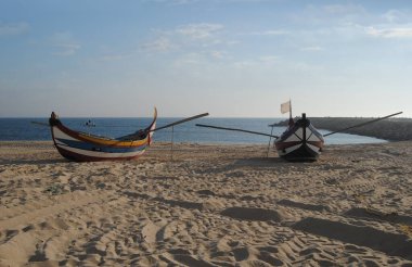 Balıkçılık endüstrisinin farklı renklerinde iki tekne kumsalda durdu.