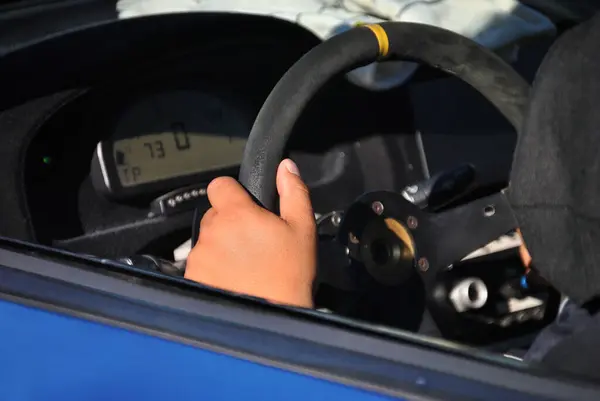 Camdan bir spor arabaya, direksiyona ve şoförün ellerine bak.