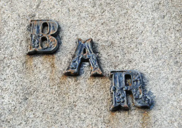 Duvara kazınmış metal harfler. Portekizce 