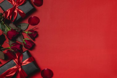 Hediye kutusu ve kırmızı güllerle süslenmiş düz bir sevgililer günü arkaplanı